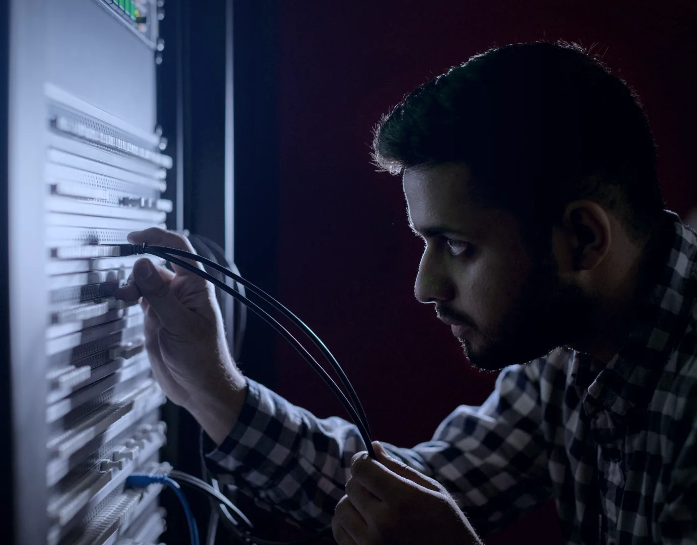 Tradesman working on an electrical panel at night